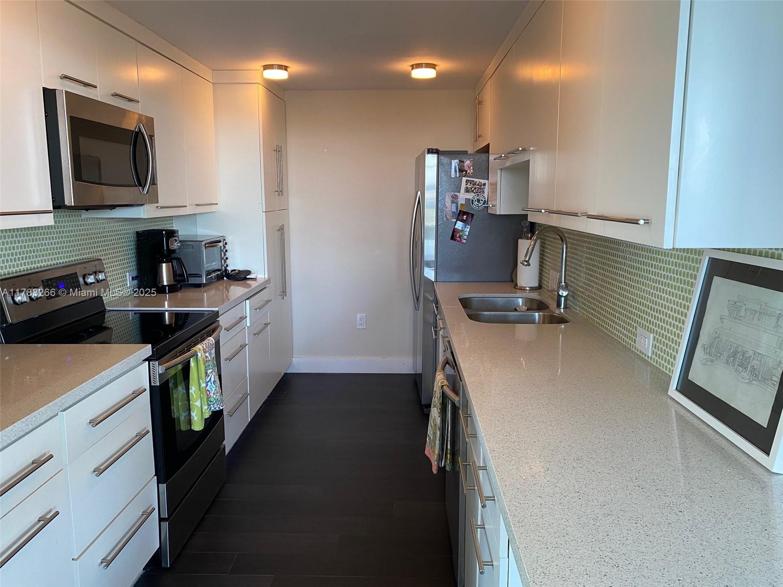 150 Southeast 25th Road, Unit 7A Miami, FL 33129 - Photo 7 of 18 a kitchen with a sink appliances and cabinets