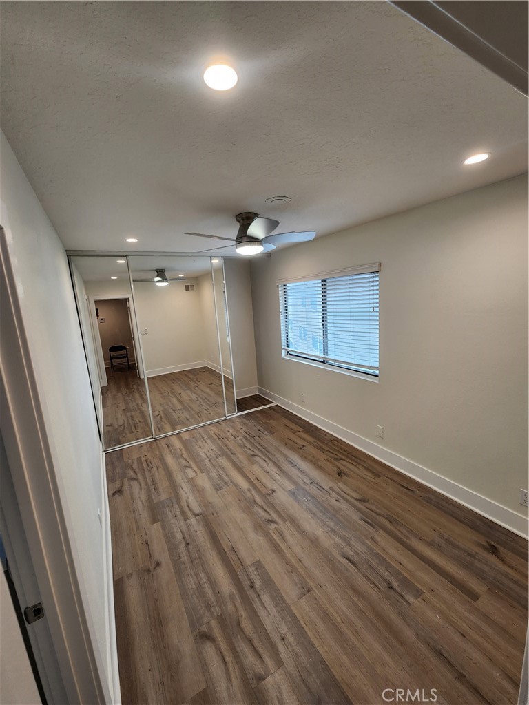 418 Avenida Santa Barbara, Unit B San Clemente, CA 92672 - Photo 22 of 52 an empty room with wooden floor and windows