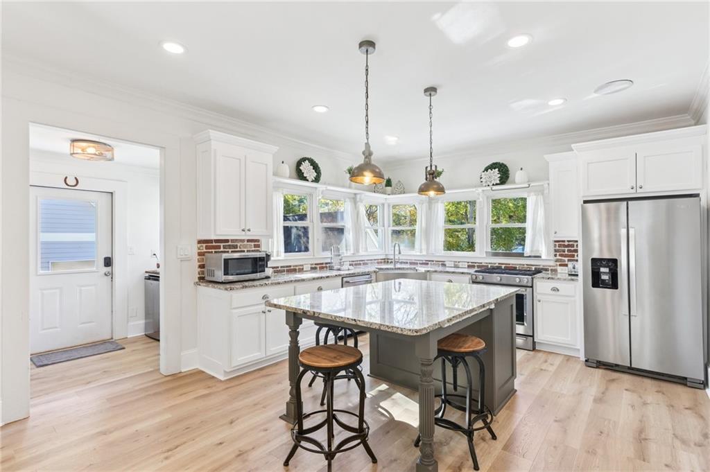 29 Sessions Street Northwest Marietta, GA 30060 - Photo 6 of 39 a kitchen with stainless steel appliances granite countertop a stove a refrigerator a oven a sink with a dining table and chairs