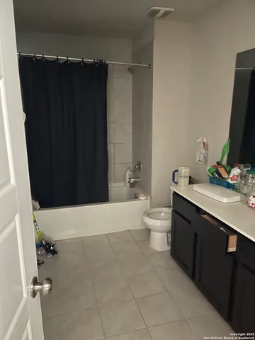 a bathroom with a double vanity sink toilet and a tub