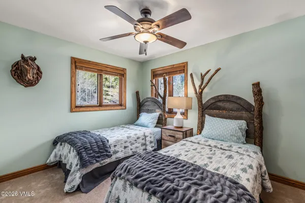 a bedroom with two beds and a chandelier