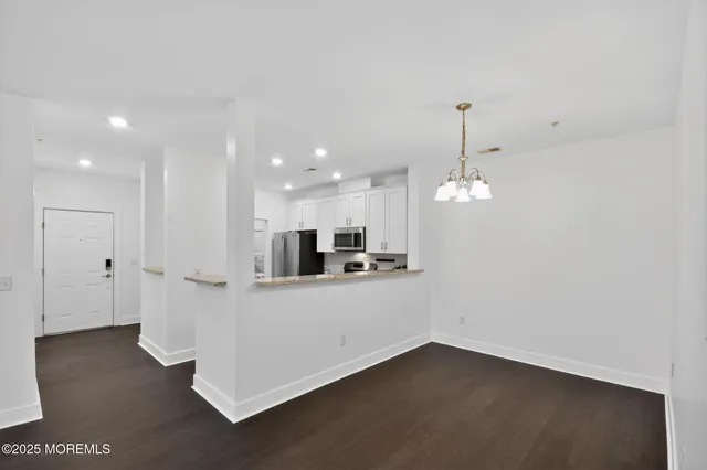 a view of a kitchen with a sink dishwasher a refrigerator and wooden floor