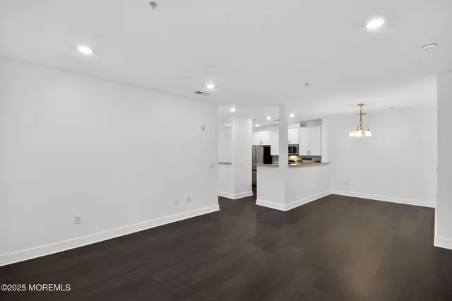 a view of kitchen with kitchen island a sink wooden floor and a refrigerator