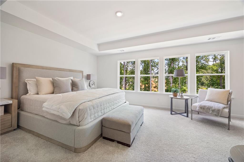 1567 Aiden Way, Unit 34 Conyers, GA 30013 - Photo 17 of 28 a spacious bedroom with a large bed and a large window