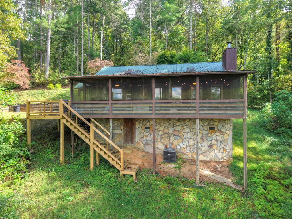 a view of house with roof deck and garden