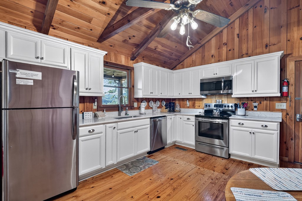 421 Salem Valley Road Mineral Bluff, GA 30559 - Photo 23 of 33 a kitchen with cabinets stainless steel appliances and a chandelier