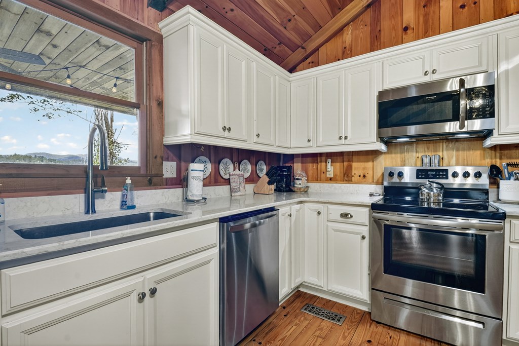 421 Salem Valley Road Mineral Bluff, GA 30559 - Photo 25 of 33 a kitchen with stainless steel appliances granite countertop a stove a sink and a microwave
