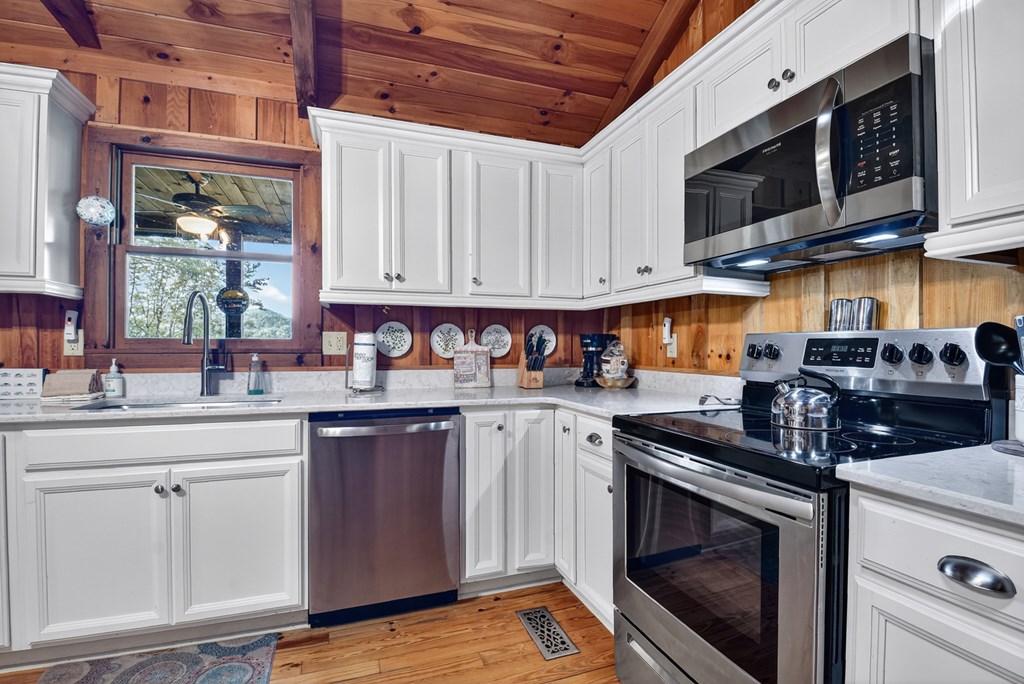 421 Salem Valley Road Mineral Bluff, GA 30559 - Photo 26 of 33 a kitchen with stainless steel appliances granite countertop a stove a sink and a microwave