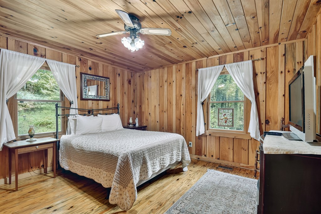 421 Salem Valley Road Mineral Bluff, GA 30559 - Photo 28 of 33 a bedroom with a large bed and a chandelier