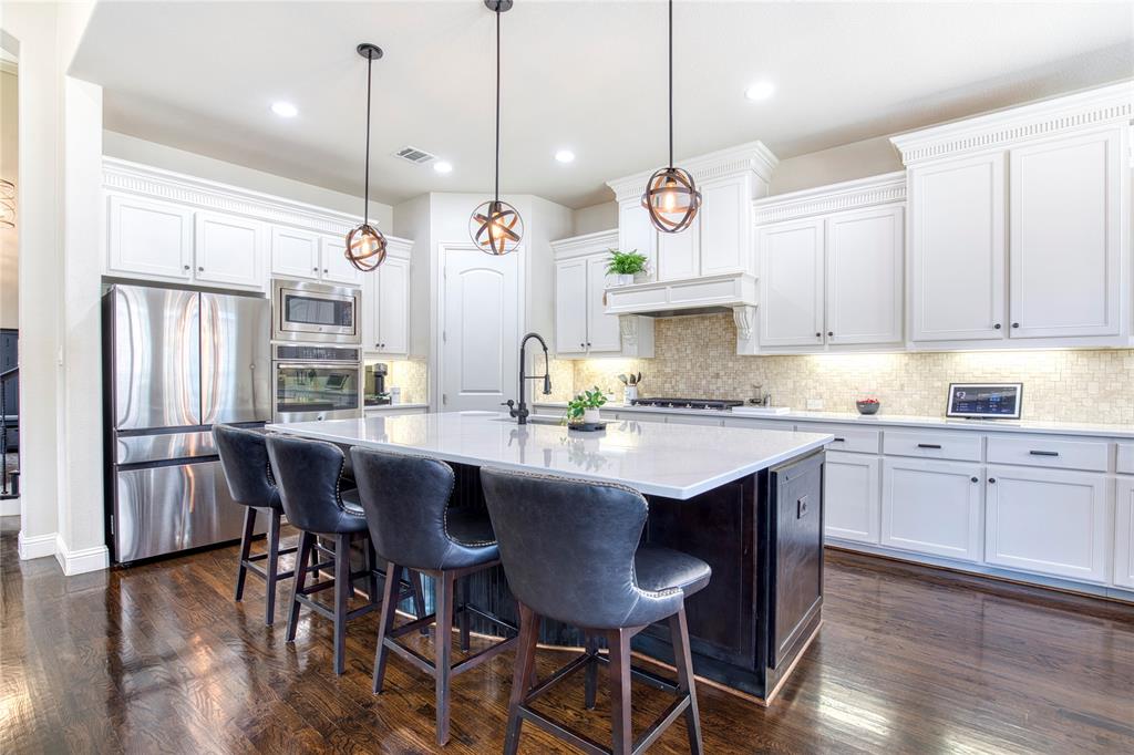1552 Saddle Tree Road Frisco, TX 75036 - Photo 14 of 40 Updated beautiful kitchen featuring large center island, pendant and canned lights, white cabinets, updated quartz counters, newer gas cooktop and double oven