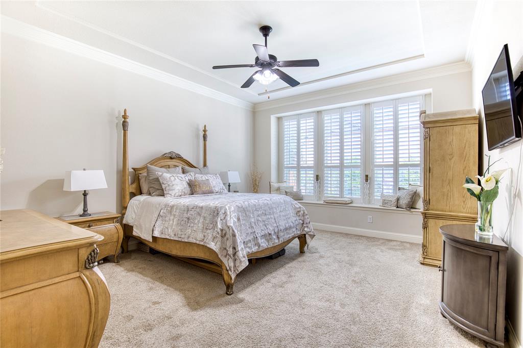 1552 Saddle Tree Road Frisco, TX 75036 - Photo 18 of 40 Large primary suite located on first level in the rear of the home. Notice the unique tray ceiling, crown molding and unique built in window seat