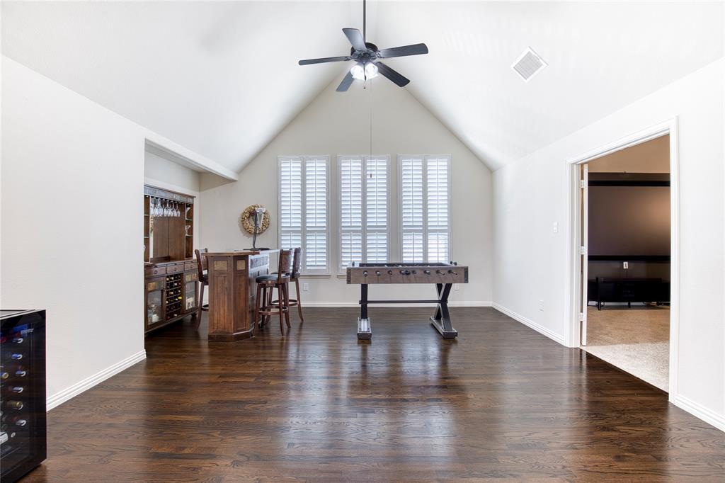 1552 Saddle Tree Road Frisco, TX 75036 - Photo 23 of 40 Large game room space upstairs featuring wood flooring, arched ceilings, ceiling fan, plantation shutters and leads to media room