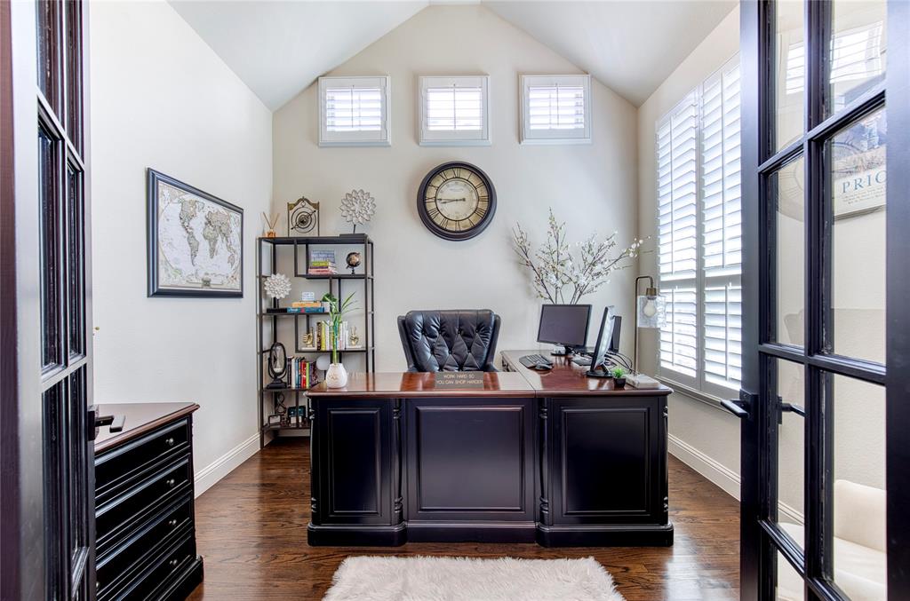 1552 Saddle Tree Road Frisco, TX 75036 - Photo 5 of 40 Handsome home office located off the entrance that features ample windows for natural light, wood flooring, plantation shutters and french doors.
