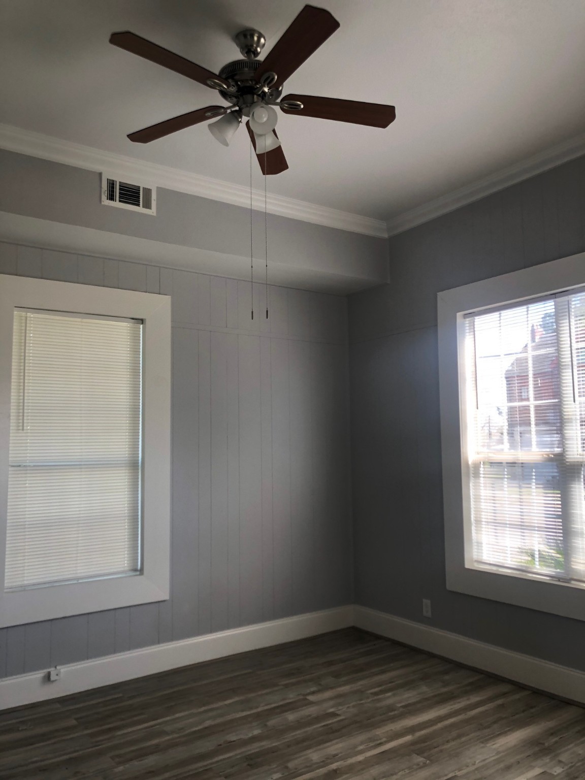 2210 Sabine Pass Avenue Beaumont, TX 77701 - Photo 2 of 10 an empty room with wooden floor fan and windows