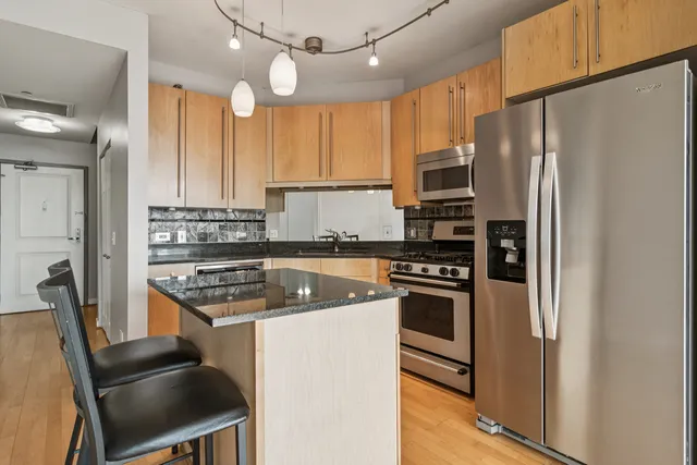 a kitchen with stainless steel appliances granite countertop a stove refrigerator and a sink