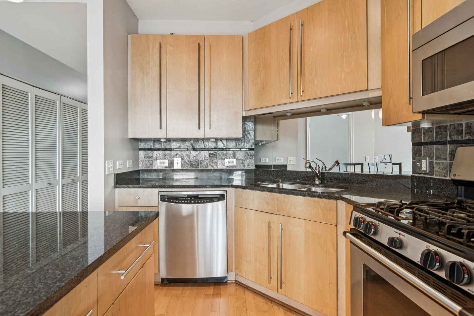 720 West Randolph Street, Unit 502 Chicago, IL 60661 - Photo 7 of 22 a kitchen with stainless steel appliances granite countertop a stove a sink and white cabinets