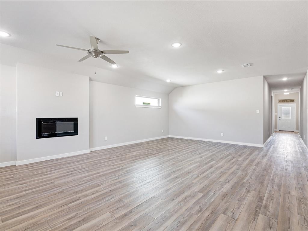 643 Medinah Road Red Oak, TX 75154 - Photo 4 of 28 a view of an empty room with wooden floor and a ceiling fan