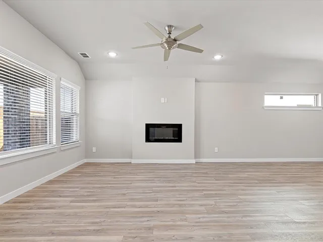 a large kitchen with stainless steel appliances granite countertop a stove a sink dishwasher a refrigerator and a microwave oven with wooden floor