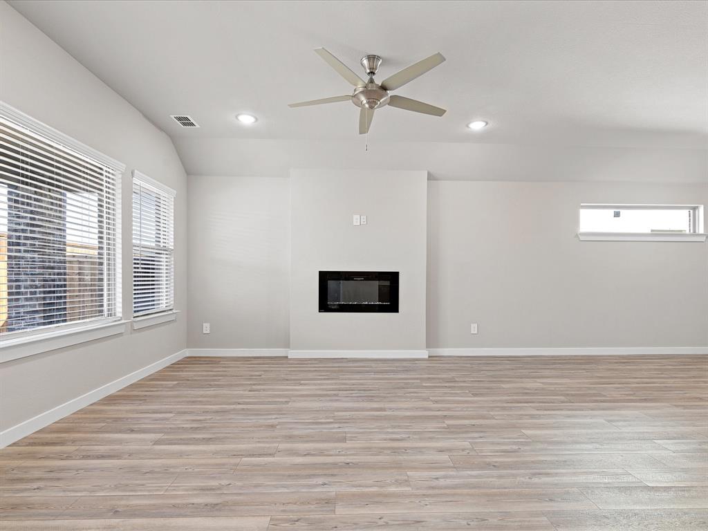 643 Medinah Road Red Oak, TX 75154 - Photo 7 of 28 a view of an empty room with wooden floor and a window