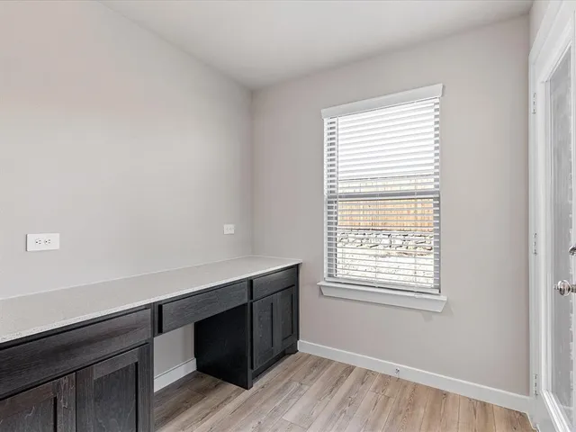 an empty room with chandelier fan and windows