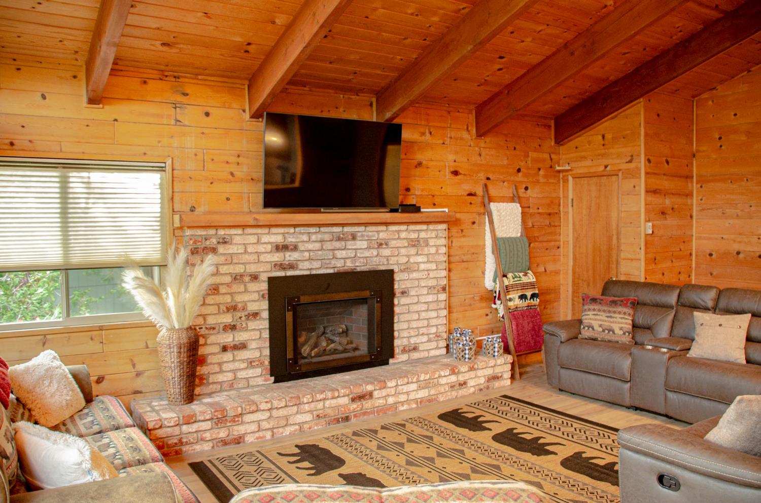 24033 Pine Cone Road Mi Wuk Village, CA 95346 - Photo 17 of 80 a living room with furniture a flat screen tv and a fireplace