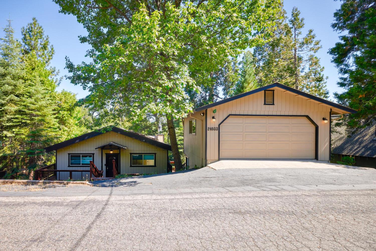 24033 Pine Cone Road Mi Wuk Village, CA 95346 - Photo 3 of 80 a front view of a house with a yard and garage