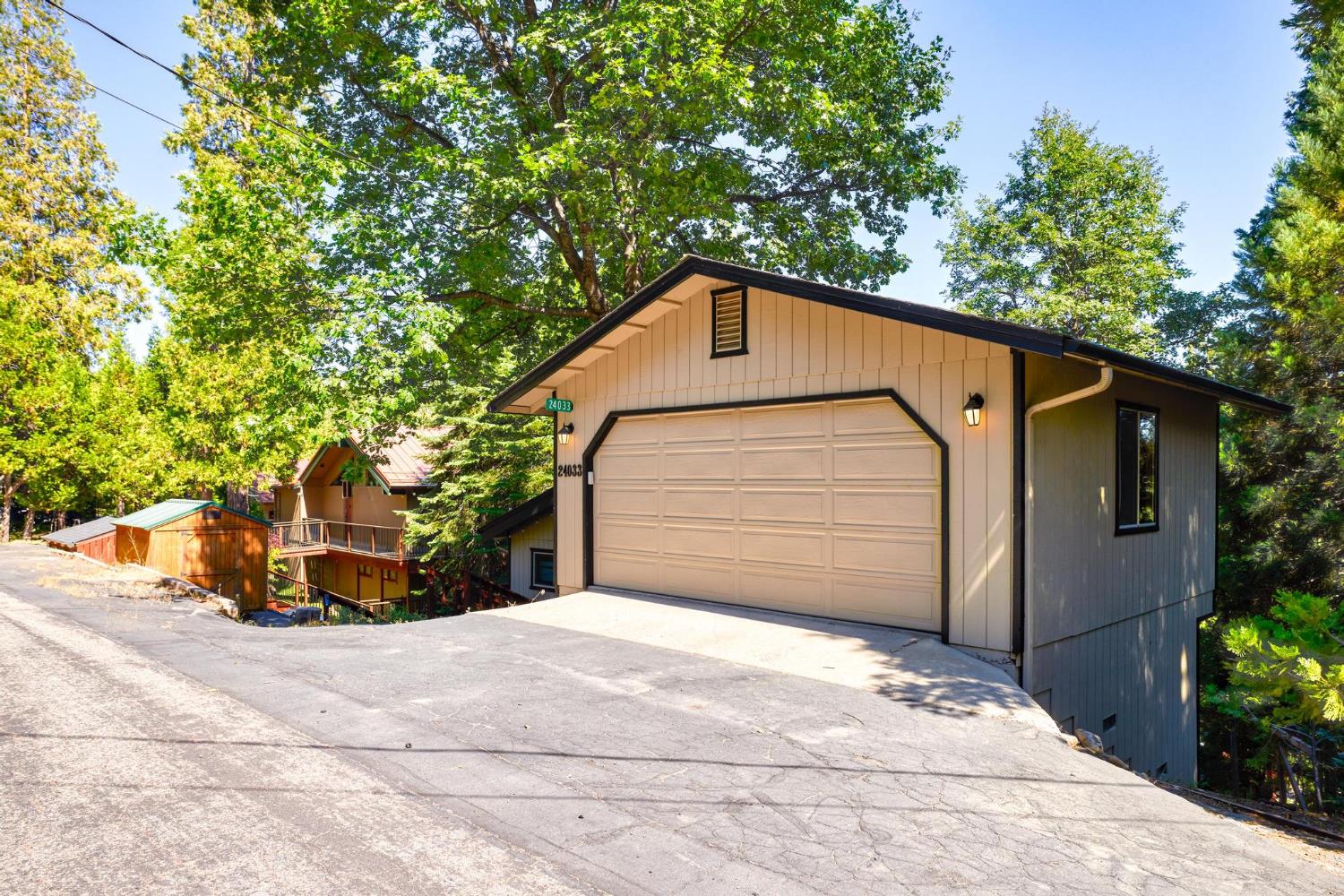 24033 Pine Cone Road Mi Wuk Village, CA 95346 - Photo 4 of 80 a front view of a house with a garage