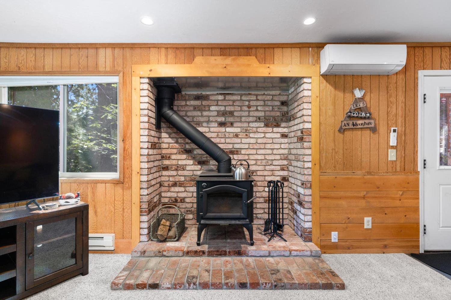 24033 Pine Cone Road Mi Wuk Village, CA 95346 - Photo 58 of 80 a living room with a fireplace and a flat screen tv