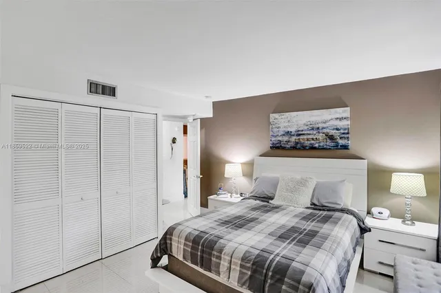 a bedroom with a bed and a painting on the wall