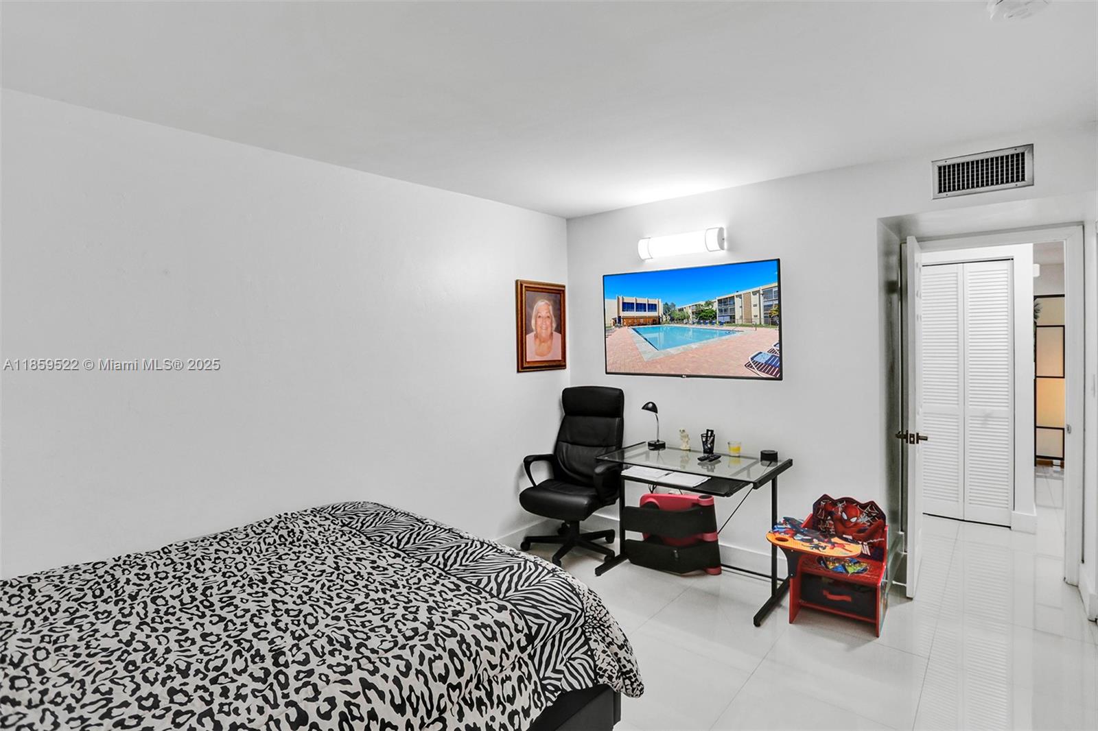 8401 Southwest 107th Avenue, Unit 111E Miami, FL 33173 - Photo 18 of 31 a bedroom with bed and a book shelf