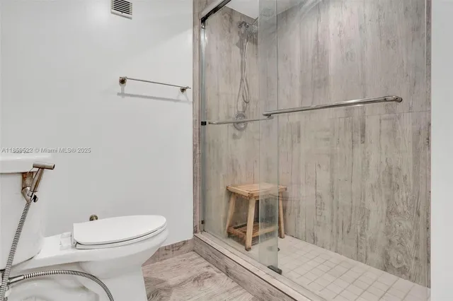 a bathroom with a toilet and a shower
