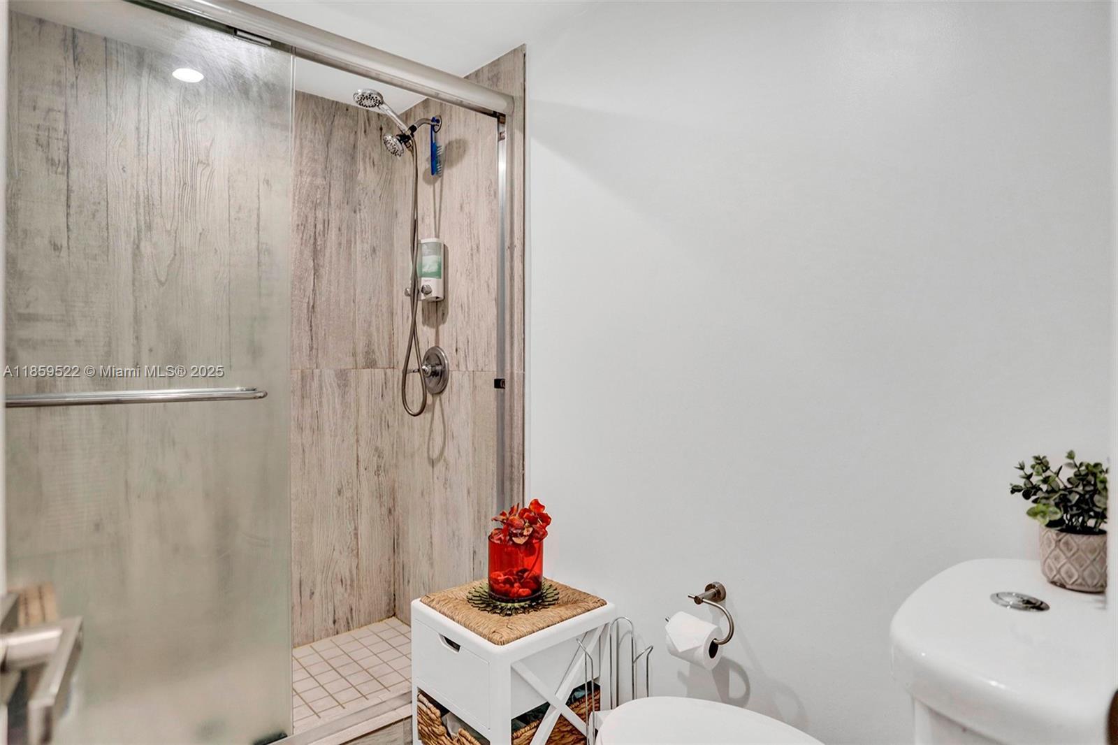 8401 Southwest 107th Avenue, Unit 111E Miami, FL 33173 - Photo 22 of 31 a bathroom with a sink a toilet and shower curtain