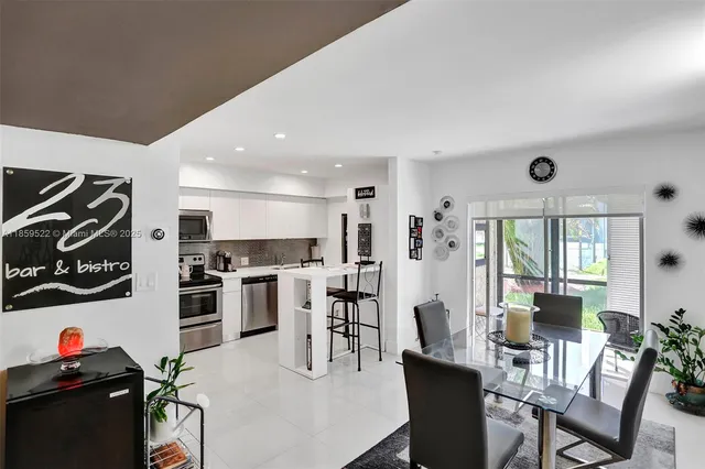 a view of a dining room with furniture a kitchen and chandelier