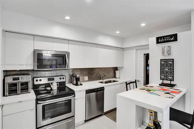 a kitchen that has a sink and a stove in it
