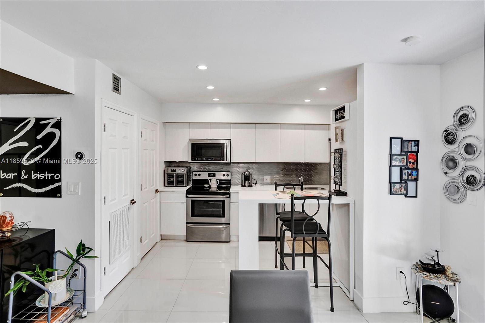 8401 Southwest 107th Avenue, Unit 111E Miami, FL 33173 - Photo 9 of 31 a kitchen with stainless steel appliances kitchen island granite countertop a stove and a refrigerator