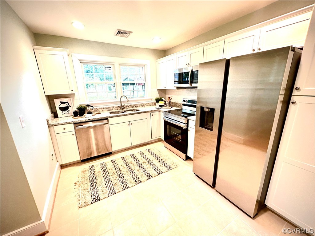 302 Main Street West Point, VA 23181 - Photo 8 of 24 a kitchen with granite countertop a refrigerator a sink a stove a washer dryer and a refrigerator