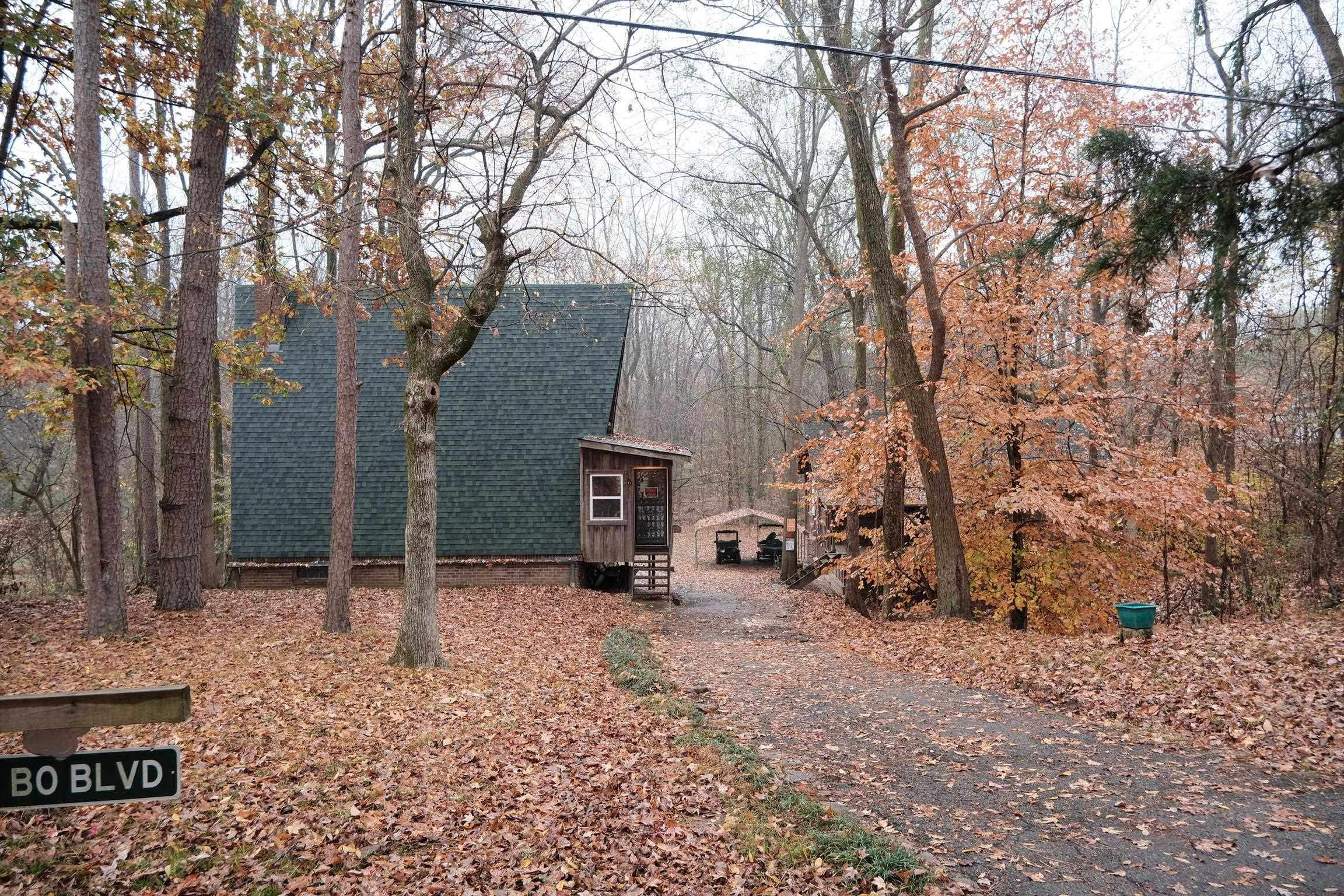 a view of house with a backyard and trees