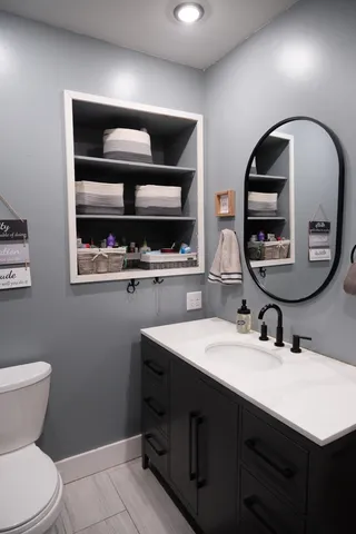 a bathroom with a toilet sink and mirror