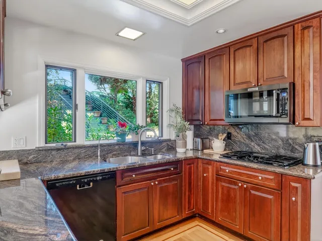a kitchen with granite countertop stainless steel appliances and cabinets