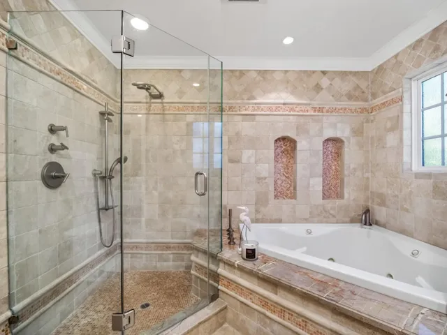 a bedroom with a large bed and a potted plant next to a window