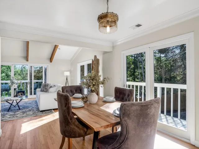 a dining room with furniture a chandelier and wooden floor