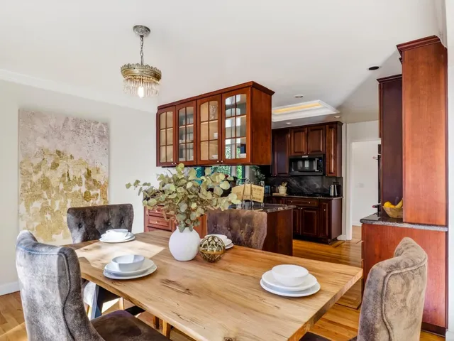 a kitchen with stainless steel appliances granite countertop a stove a sink and a dining table