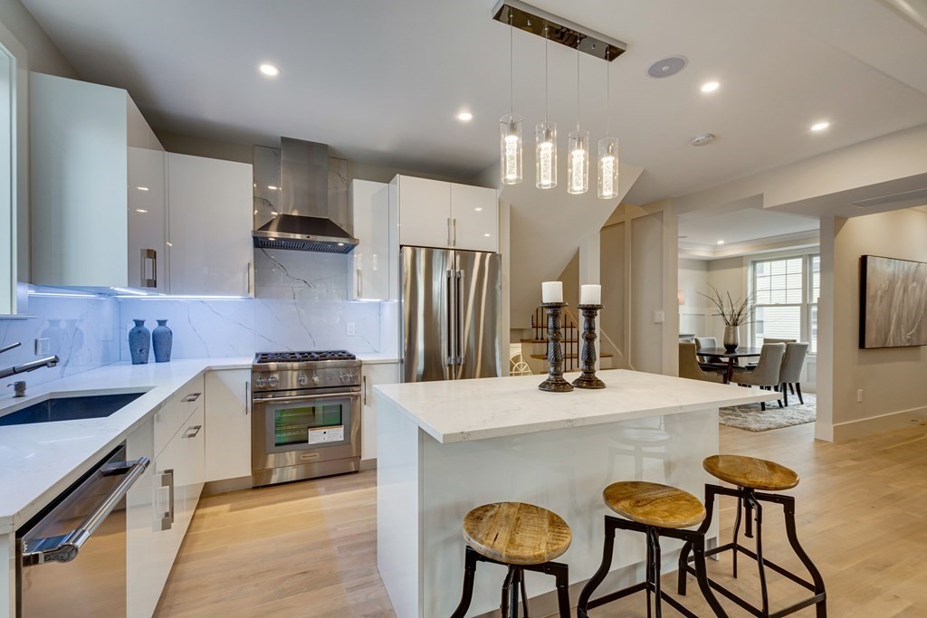 638 Webster Street, Unit 638 Needham, MA 02492 - Photo 7 of 29 a kitchen with stainless steel appliances kitchen island granite countertop a stove a sink a refrigerator and chairs