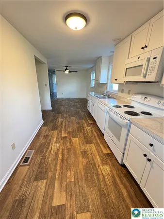 a kitchen with white cabinets and white appliances