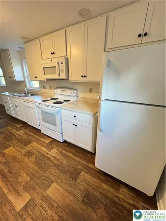 a kitchen with stainless steel appliances a refrigerator sink and white cabinets