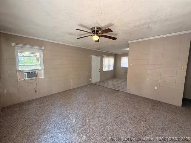 a view of a livingroom with a ceiling fan and window