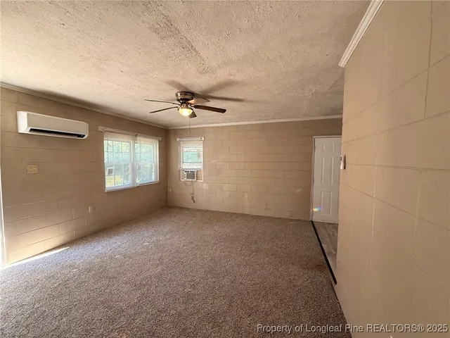 an empty room with windows and ceiling fan view