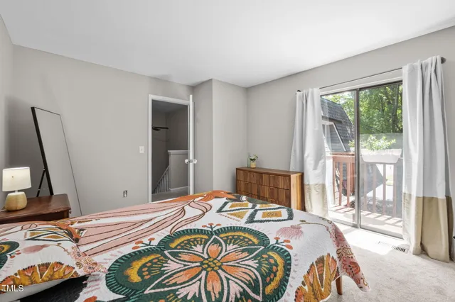 a bedroom with a bed and large windows