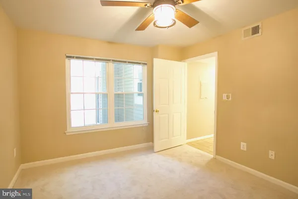 a view of an empty room with a ceiling fan