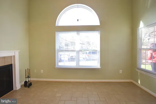 an empty room with a fireplace and windows